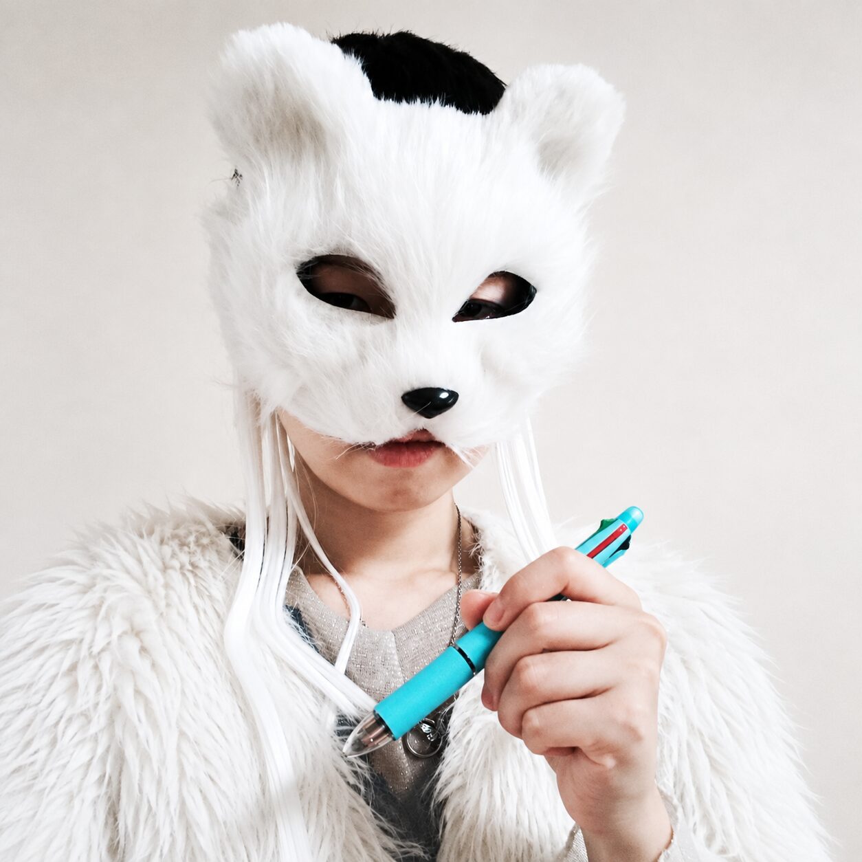 白い動物マスクとターコイズのペン